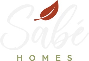 Sabé homes logo white with rusty red leaf and green accent big